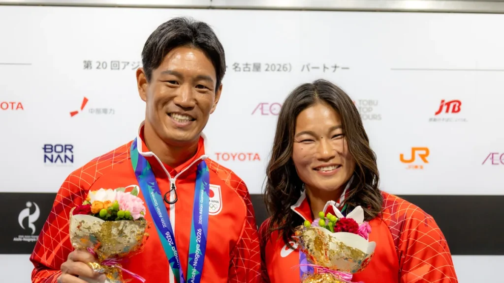 花束を手に笑顔を見せるセーリングの磯崎哲也選手と関友里恵選手