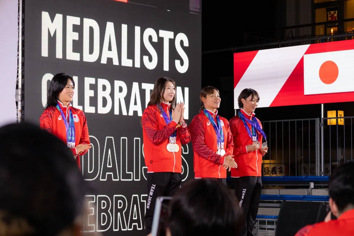 メダリストセレブレーションのステージに立つ競泳のメダリストたち