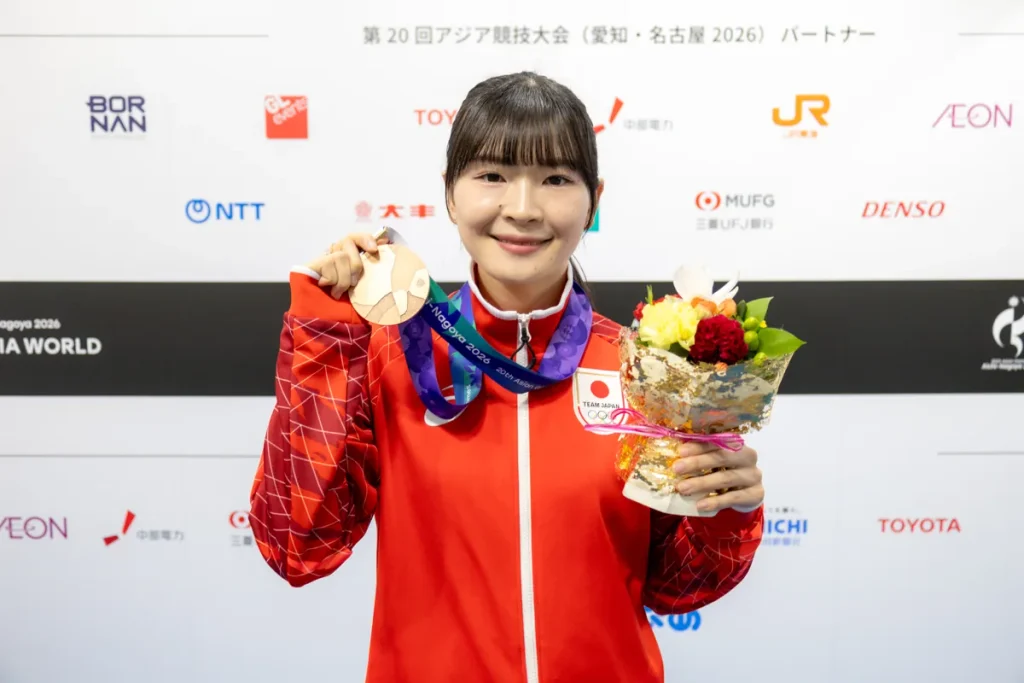 銅メダルと花束を手に笑顔を見せるテコンドーの丹羽結子選手