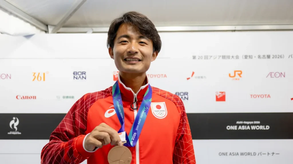 銅メダルを手に笑顔を見せるテニスの松岡隼選手