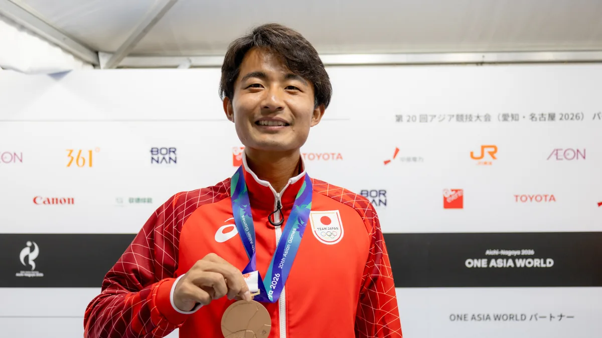 銅メダルを手に笑顔を見せるテニスの松岡隼選手