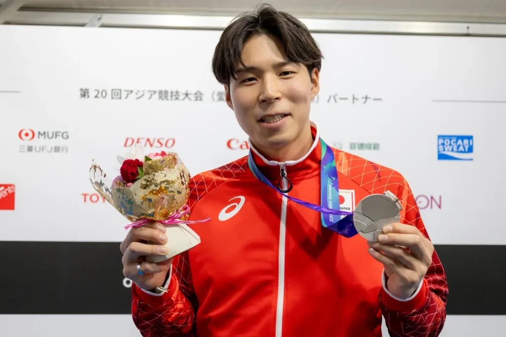 銀メダルを手に取材に応じるバレーボールの新井雄大選手