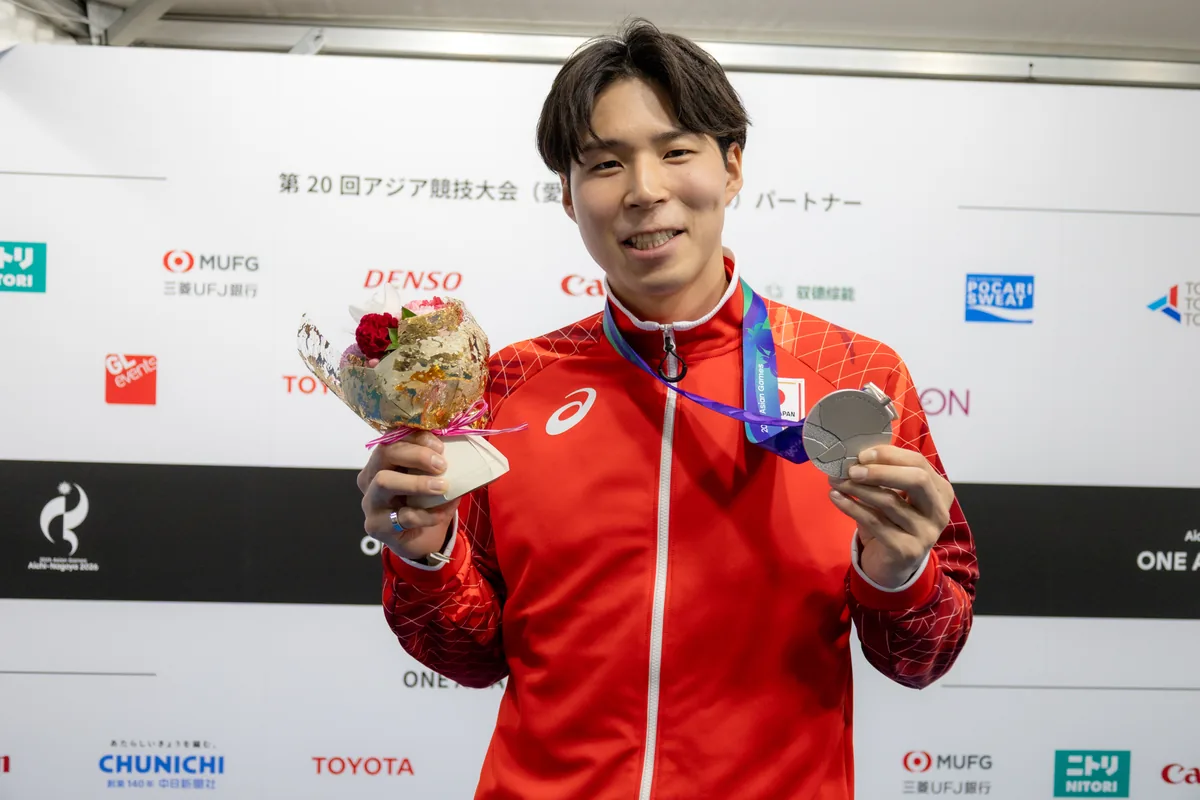 銀メダルと花束を手にするバレーボールの新井雄大選手