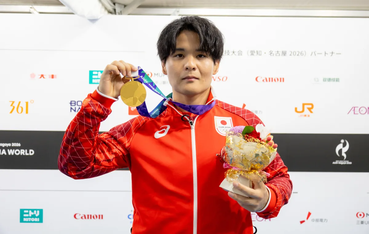 金メダルと花束を手にするレスリングの仲里優力選手