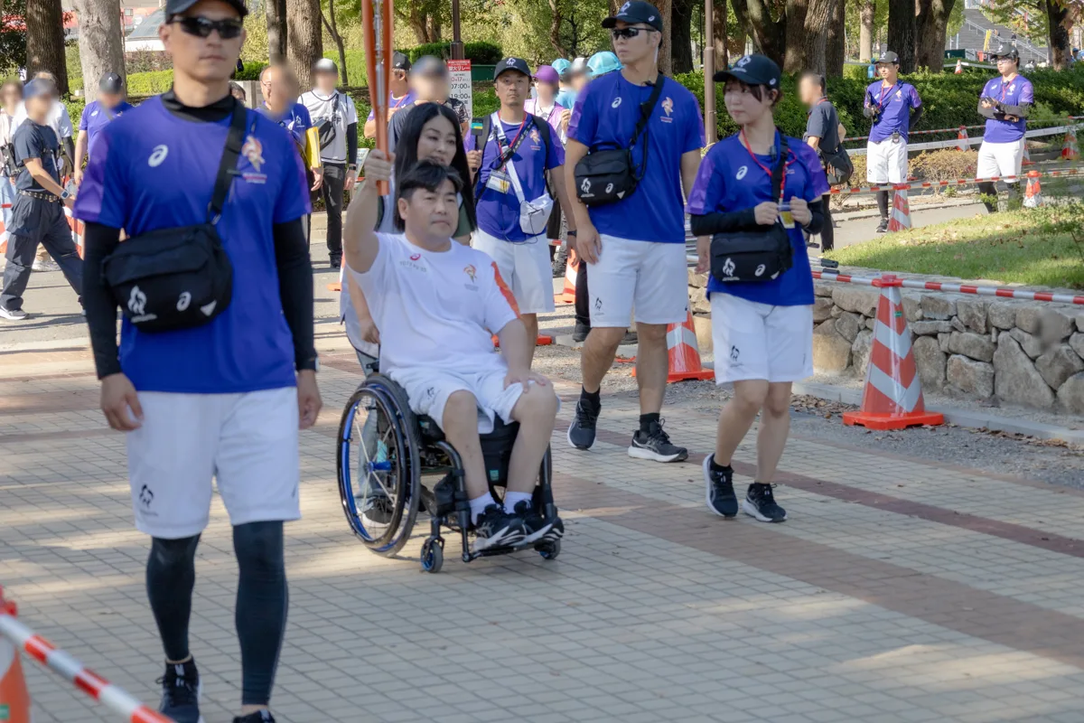 伴走のスタッフに囲まれて走る大堂秀樹さん
