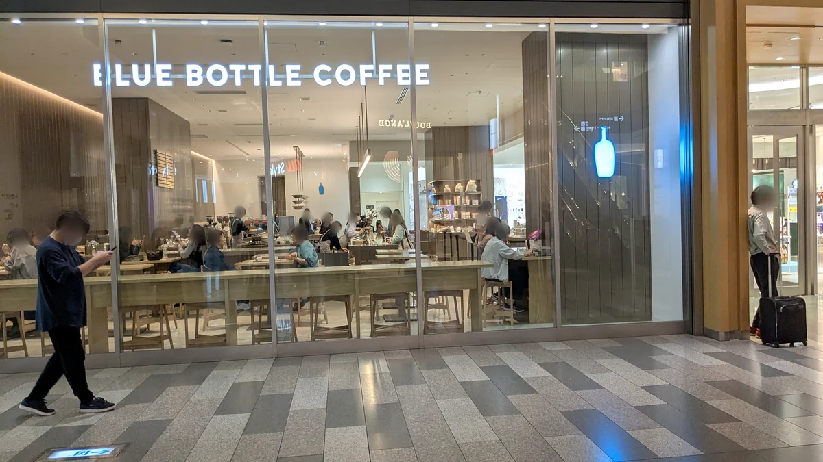 JRゲートタワー2階、ブルーボトルコーヒー 名古屋ゲートタワーモールカフェの外観。ガラス張りの店内に長いテーブル席が並ぶ