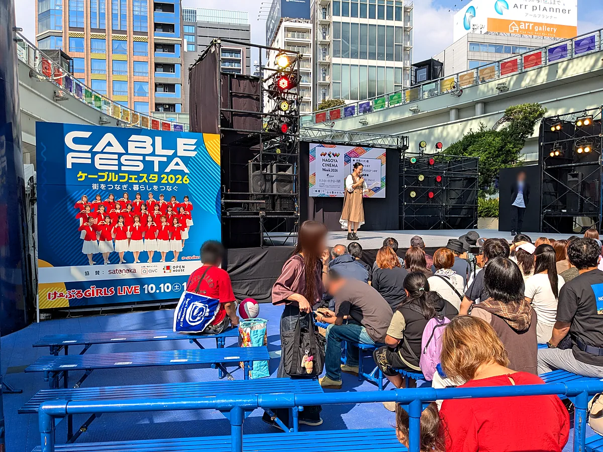 ケーブルフェスタ2026のステージと看板。ステージ前のベンチ席に人が集まる様子