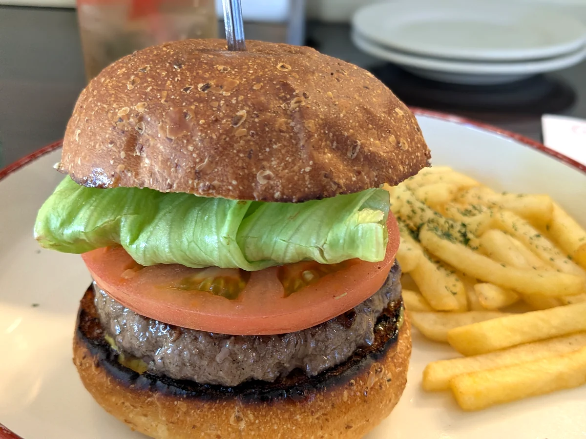 CHEDDARのクラシックバーガー（1,500円）。手切りパティにトマトとレタスを挟み、フレンチフライが添えられている