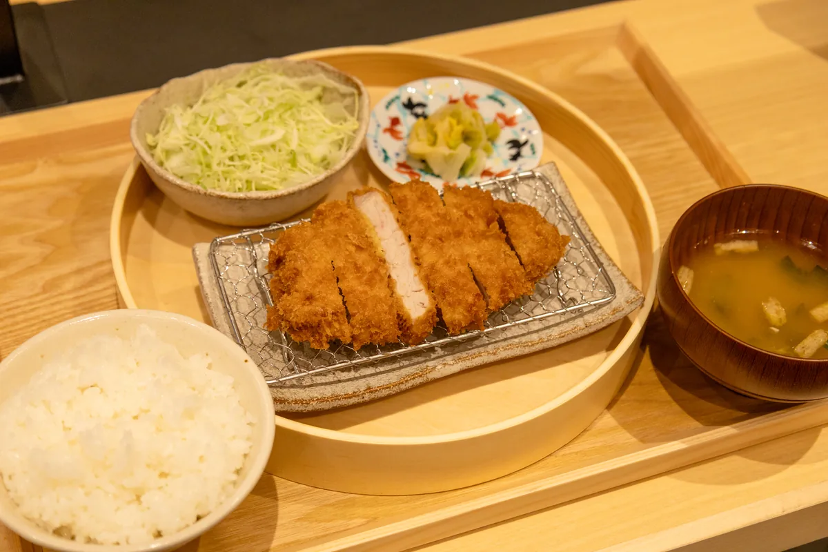 昼の「ロースかつ昼御膳」。網にのったロースかつに、ごはん・味噌汁・キャベツが付く