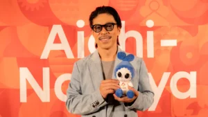 アジアパラ競技大会のマスコット「ウズミン」のぬいぐるみを手に笑顔のEXILE松本利夫さん（MATSU）。オアシス21のONE HEART WORLD囲み取材で