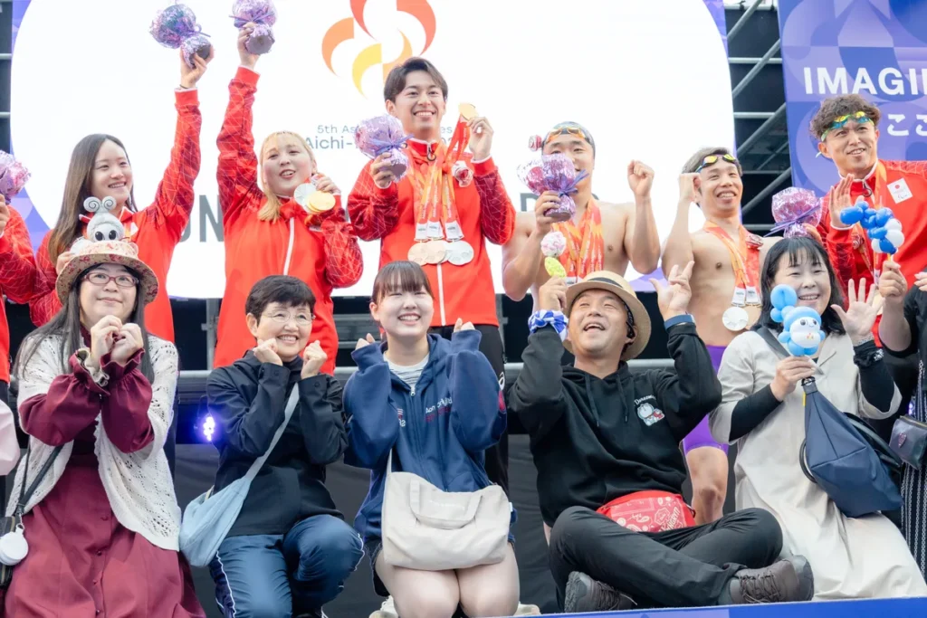 観客から選ばれたフラワーエスコートと一緒に記念撮影するパラ水泳の選手たち