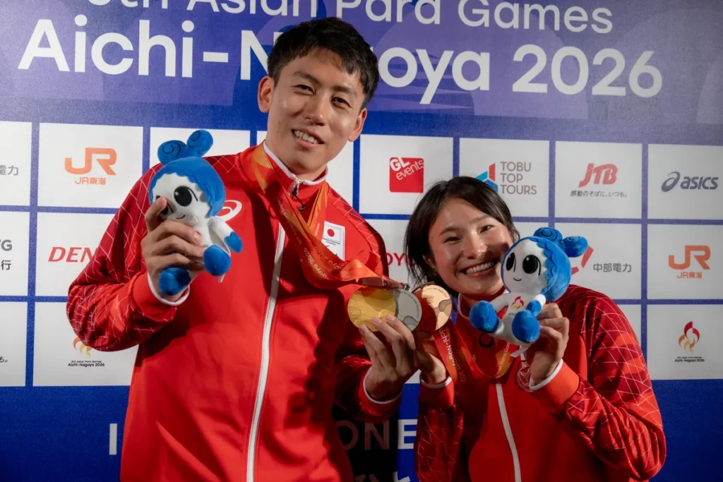 ミックスゾーンでメダルとウズミンのぬいぐるみを手にするパラ陸上の福永凌太選手と加藤茜選手