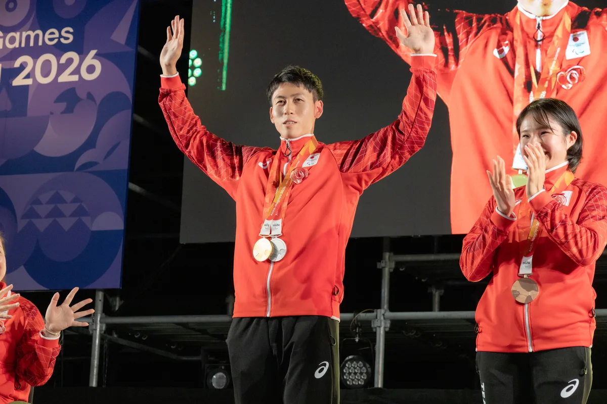金と銀の2つのメダルを掛けて両手を上げる福永凌太選手