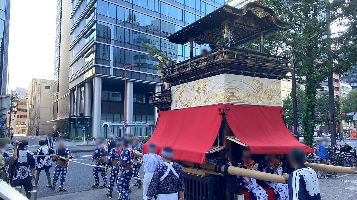 白地に金の波模様の水引幕を付けた二福神車と、山車の中で小鼓を打つ人たち