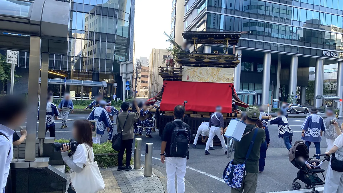交差点で二福神車の向きを変える人たちと、カメラを向ける沿道の見物客