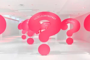 はてな展の東京会場。ピンク色の大きな「？」のオブジェに質問が書かれた展示室