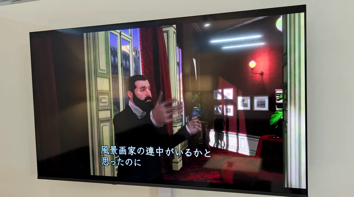 ラウンジのモニターに映る「印象派画家と過ごす夜」の一場面と「風景画家の連中がいるかと思ったのに」の字幕