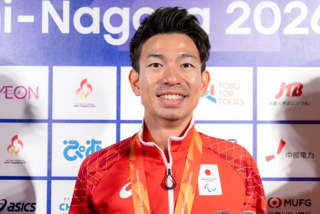 銀メダルを掛けて笑顔を見せる石田駆選手