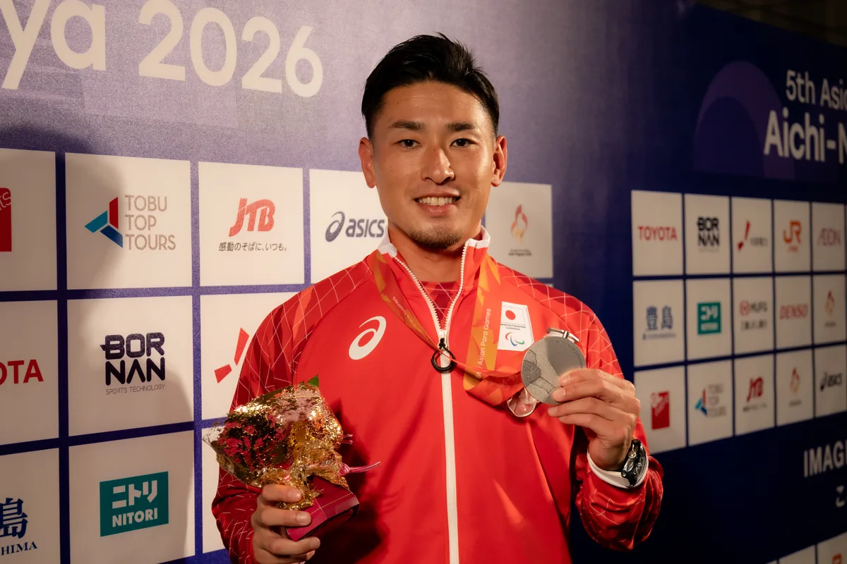 ミックスゾーンで銀メダルと花束を手に笑顔を見せるパラ陸上の井谷俊介選手