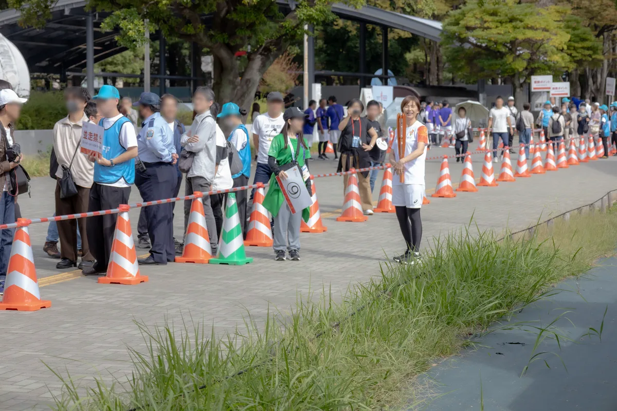 白川公園の聖火リレーのコースと沿道の観客、スタートを待つ陣内貴美子さん