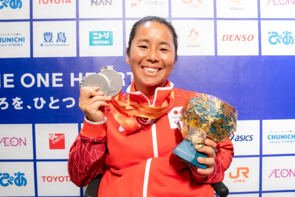 ミックスゾーンで銀メダルと花束を手にする車いすテニスの上地結衣選手