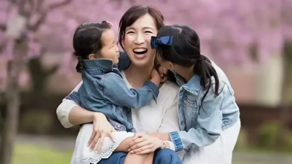 桜の下で2人の娘と笑う上条厚子さん