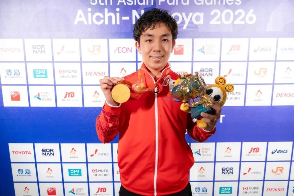 金メダルと花束を手に笑顔を見せる金子和也選手