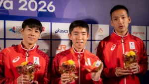 パラ陸上の唐澤剣也選手とガイドランナーの堀越翔斗さん・清水琢馬さん。金メダルと花束を手にミックスゾーンで