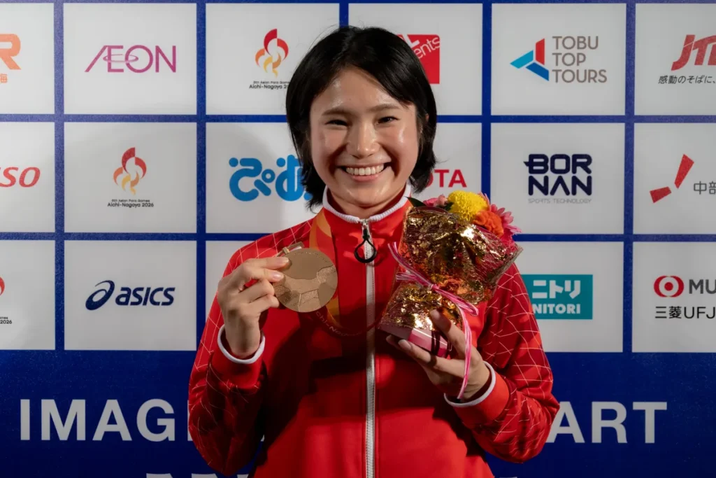 ミックスゾーンで銅メダルと花束を手に笑顔を見せる加藤茜選手
