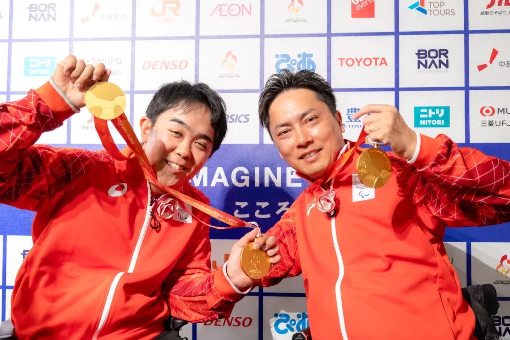 金メダルを手に笑顔を見せる川野将太選手と宇佐美慧選手