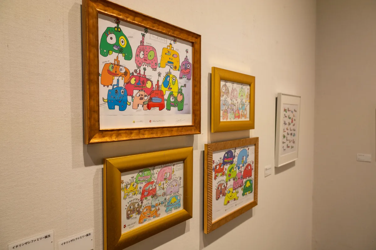金色の額に入ったカラフルなキャラクターを描いた木梨憲武さんの新作「イチリンザシファミリー」