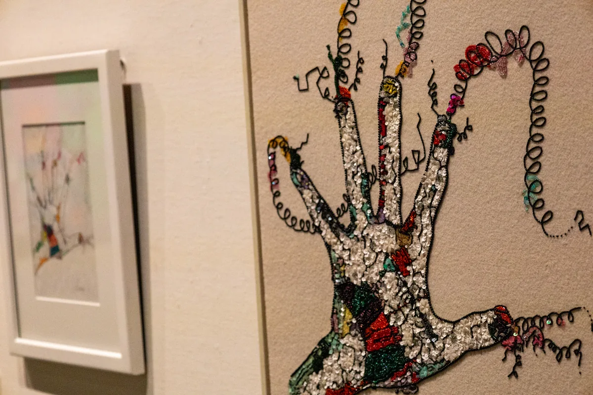 刺しゅうとビーズで手のひらを表現した木梨憲武さんの「REACH OUT」の作品