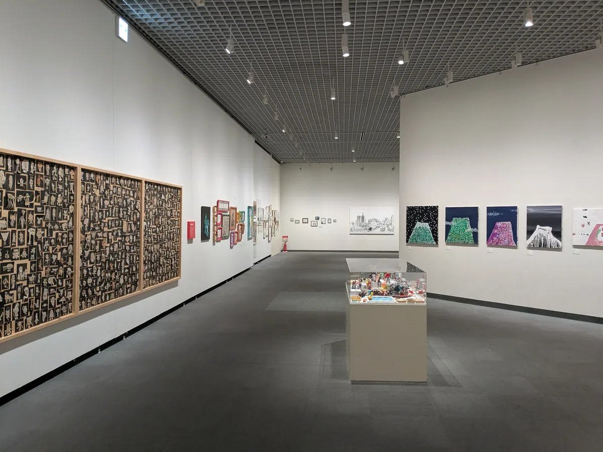 白い壁と高い天井の松坂屋美術館の展示室に木梨憲武さんの作品が並ぶ様子
