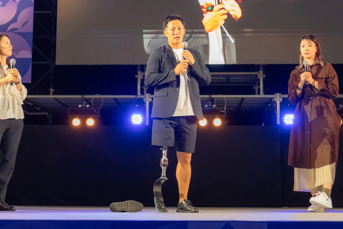 外した板バネを手に説明する小須田潤太さんと栗原三佳さん