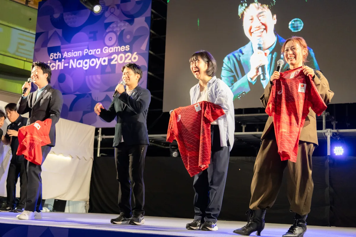 サイン入りのウェアを手にする4人