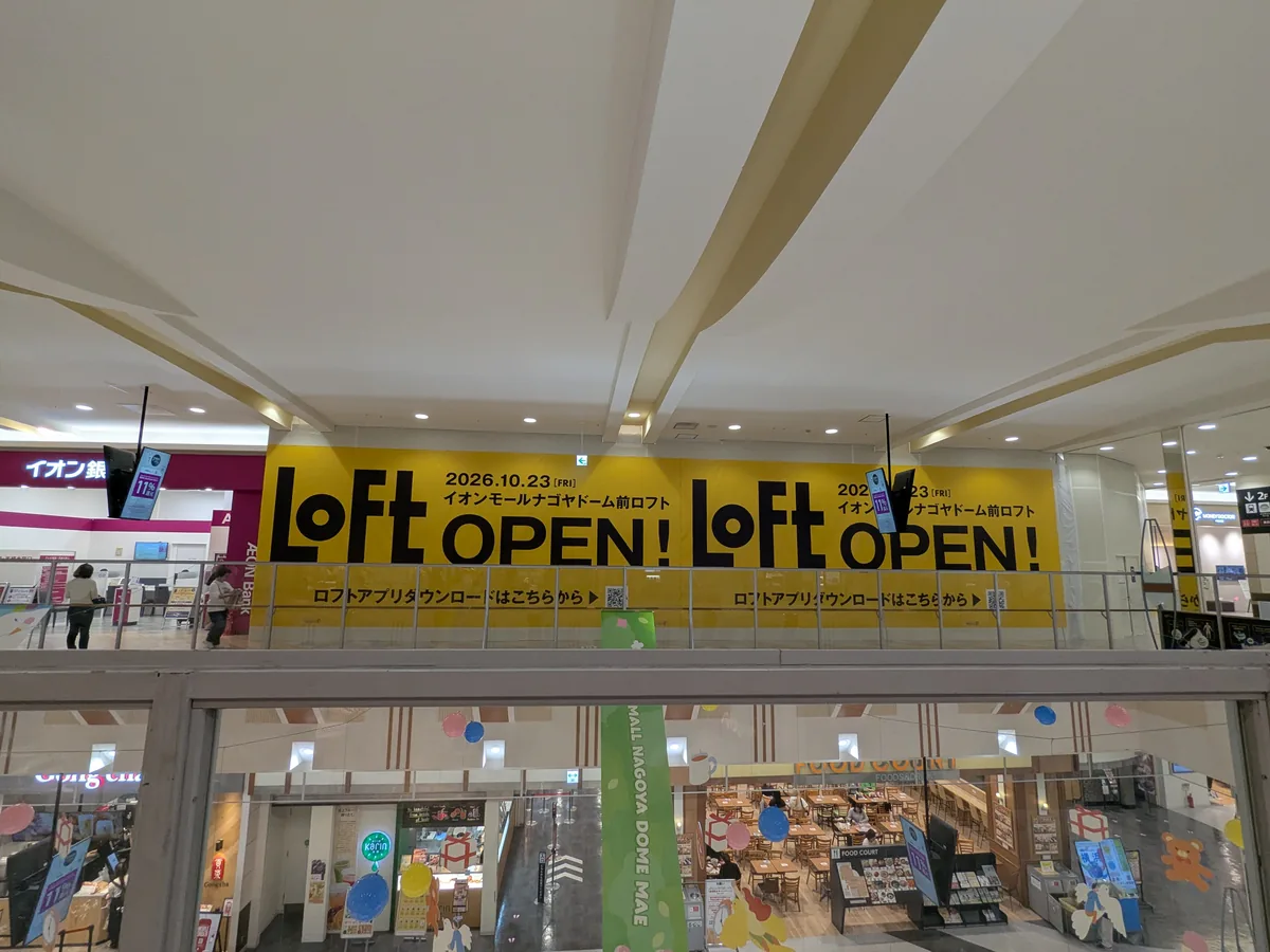 吹き抜けの向こう、イオン銀行のとなりに並ぶロフトの告知看板。下の階は2階のフードコート