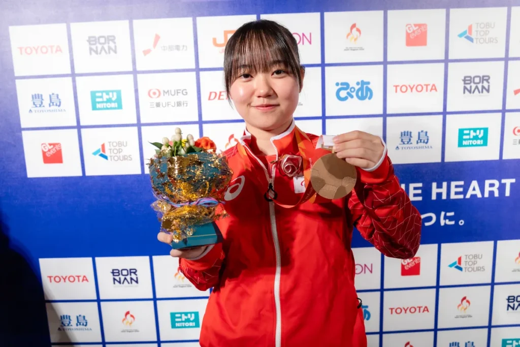 ミックスゾーンで銅メダルと花束を手にするパラ卓球の三浦稟々選手
