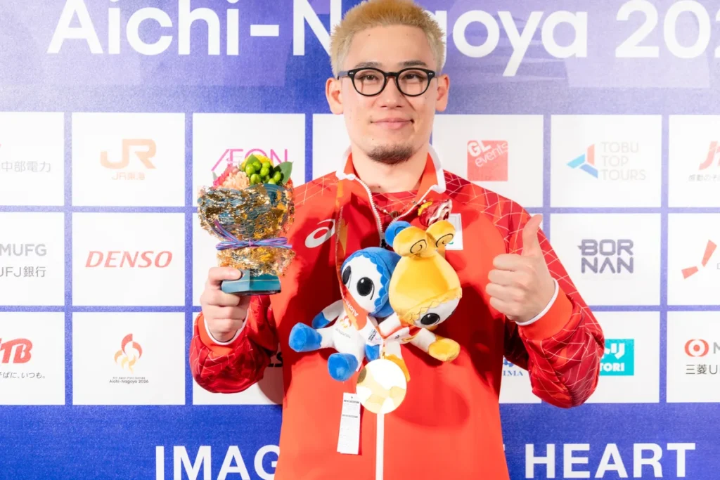 ミックスゾーンで金メダルと花束、ウズミンのぬいぐるみを手にするゴールボールの宮食行次選手