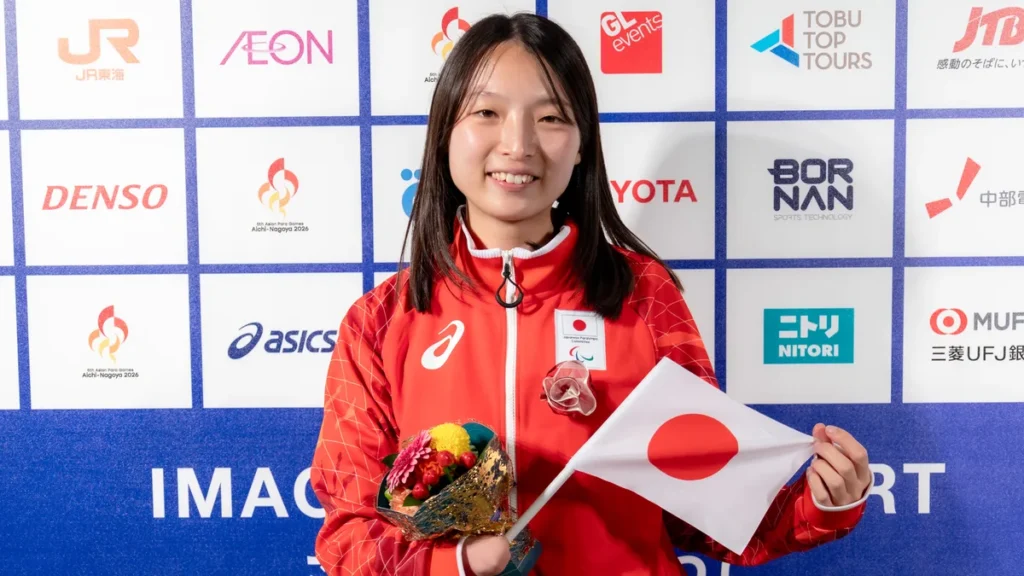 パラ陸上の中川もえ選手。日の丸の小旗と花束を手に