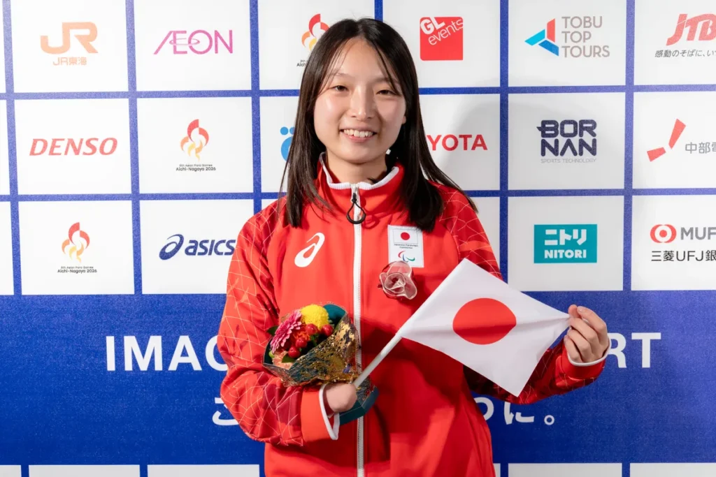 日の丸の小旗と花束を手にミックスゾーンに立つ中川もえ選手