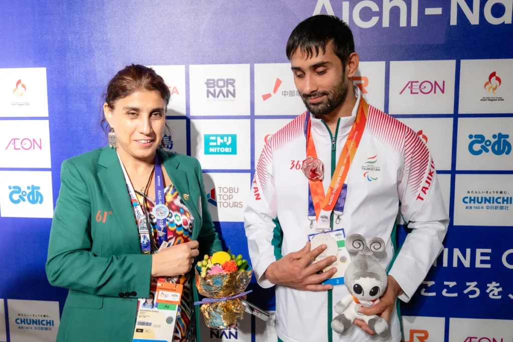 ミックスゾーンで通訳の方と並ぶタジキスタンのパラ柔道、ショフルフ・ナザロフ選手。銀メダルと花束、ウズミンのぬいぐるみを手に