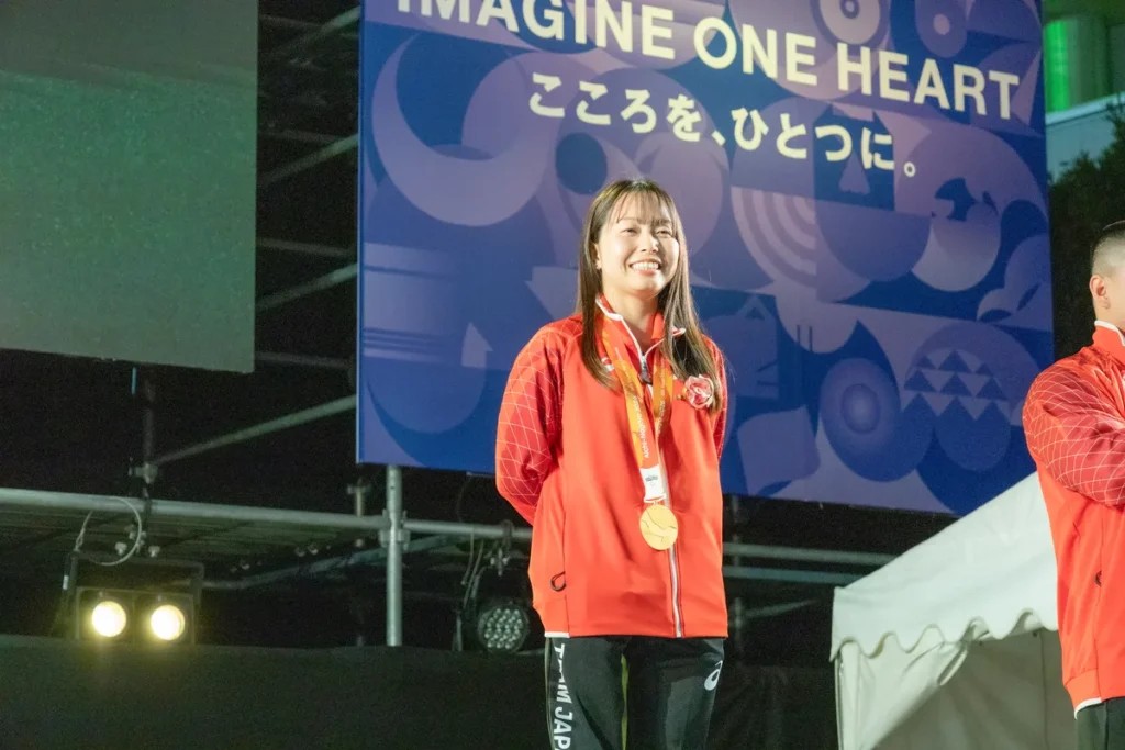金メダルを掛けてステージに立つ西田杏選手