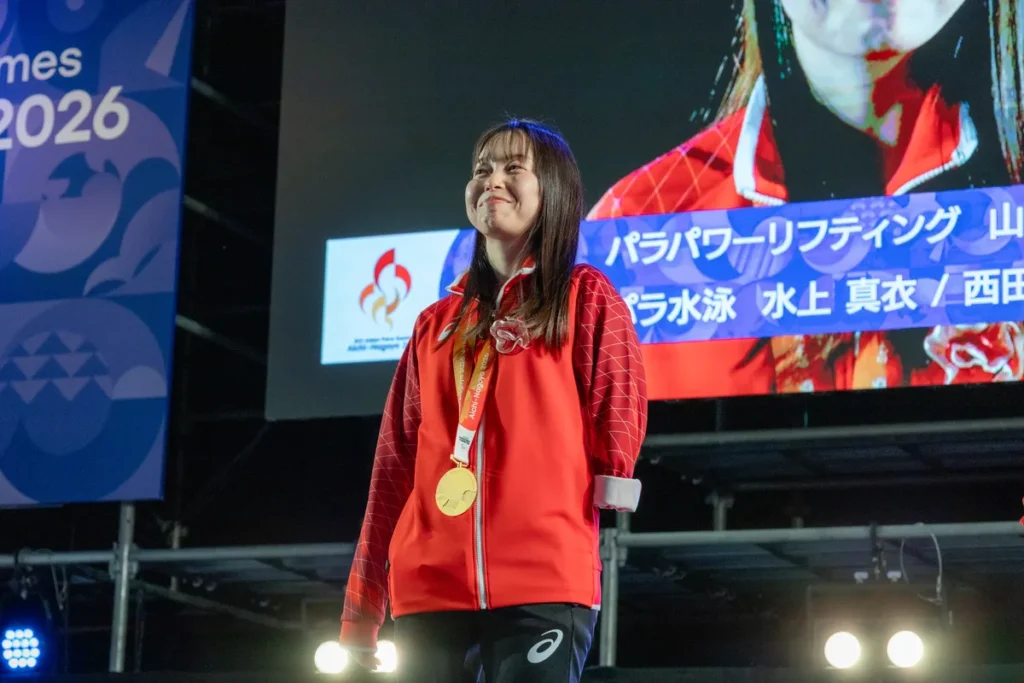 金メダルを掛けてステージに立つ西田杏選手
