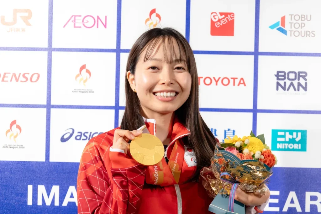 ミックスゾーンで金メダルと花束を手にするパラ水泳の西田杏選手