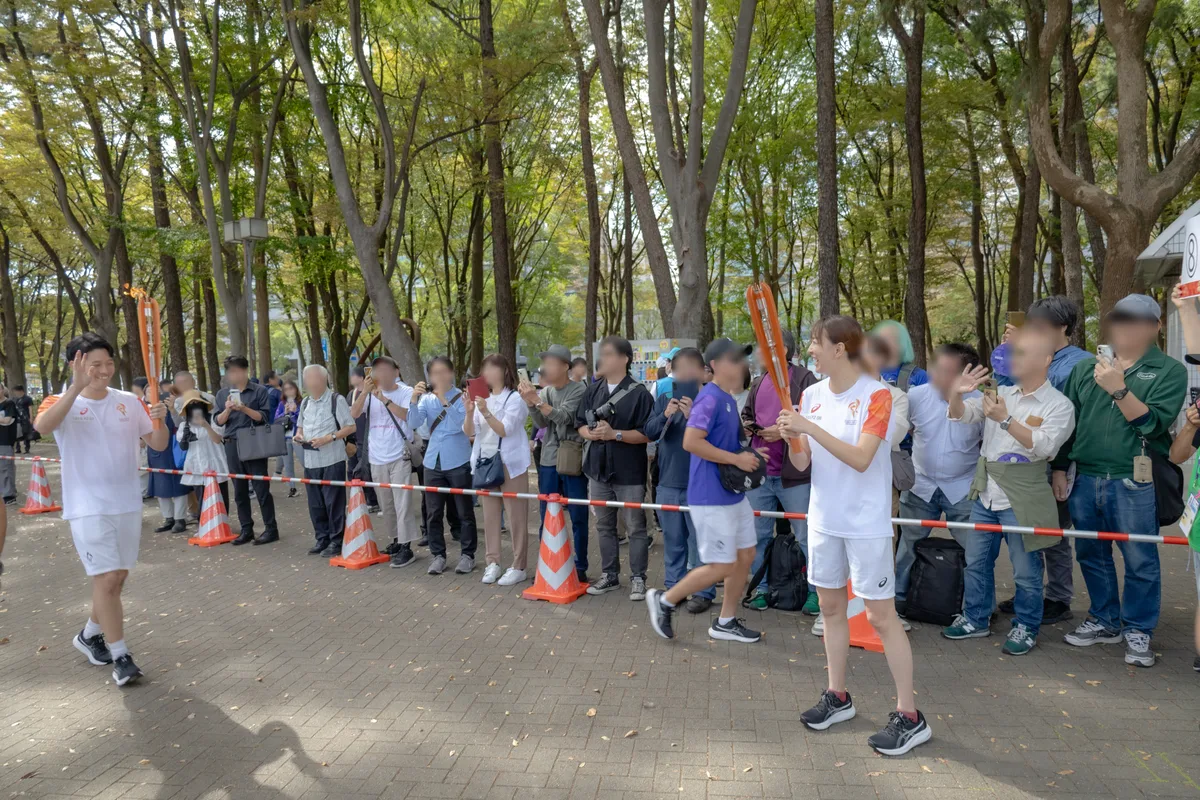 聖火を持って白川公園を走る小椋久美子さん