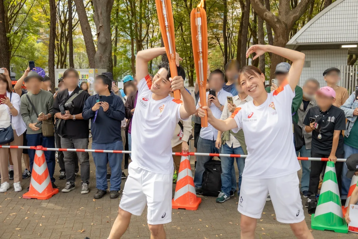 前のランナーと一緒にトーチを掲げる小椋久美子さん