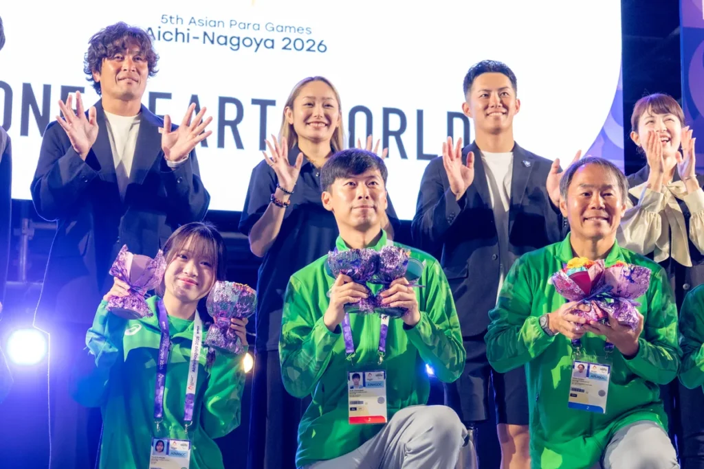 ONE HEART WORLDのステージで花束を手にする公式ボランティア「ONE ASIA CREW」の皆さんと、後ろに並ぶ大畑大介さん、安藤美姫さん、小須田潤太さん、平井理央さん