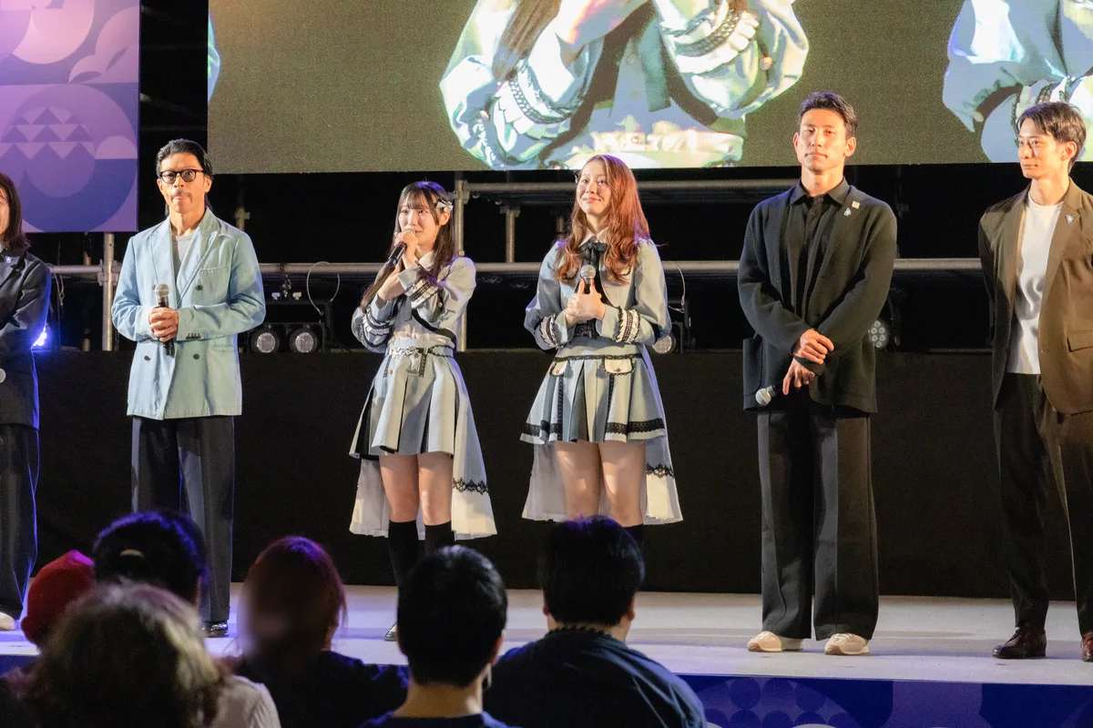 ONE HEART WORLDのオープニングトークショーでマイクを持つ松本利夫さん。隣にSKE48の倉島杏実さんと松本慈子さん、塚原直貴さん、入江陵介さん