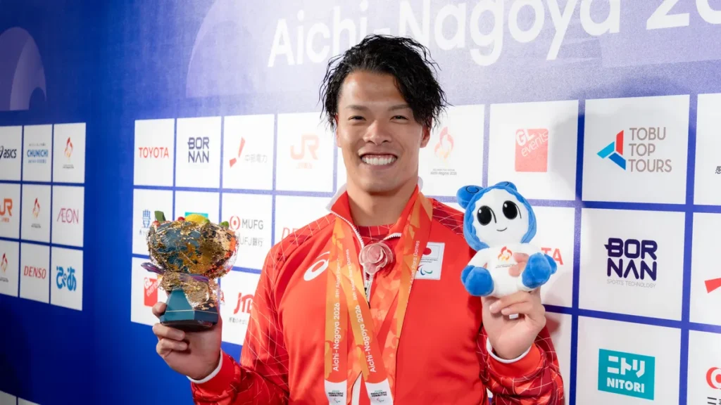 パラ陸上の大島健吾選手。2つの金メダルと花束、ウズミンのぬいぐるみを手に