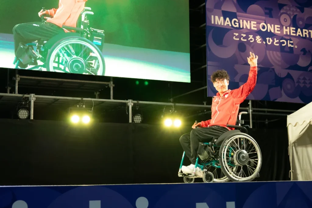 車いすで客席に手を振るパラアーチェリーの大山晃司選手